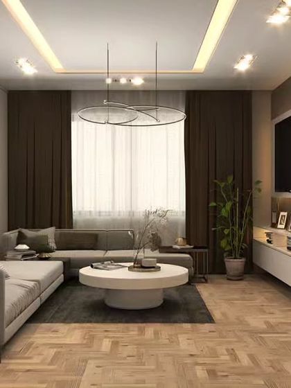 This living room design combines a neutral color palette with herringbone wood flooring and a modern false ceiling. The result is a bright, airy, and sophisticated space that feels both contemporary and timeless.