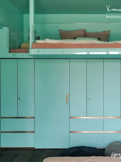 The loft bed in Project 704 is integrated with a full wall of wardrobe storage below. One of the wardrobe doors is a secret entrance to the bathroom, keeping the room's design clean and adding an element of fun.