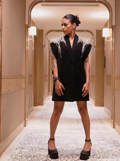 Anasuya Sengupta in a powerful stance, showcasing her full Gaurav Gupta look. The architectural hallway provides a perfect, symmetrical backdrop for this fashion-forward portrait.