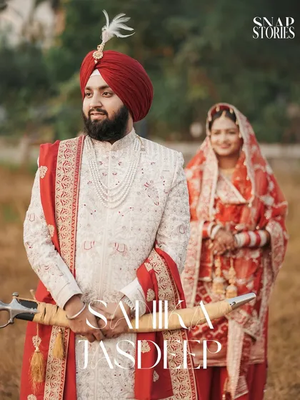 A regal portrait of the Sikh groom in his sherwani, holding the kirpan, with his bride in the background. We create classic portraits that honor the traditional attire of a Punjabi wedding.