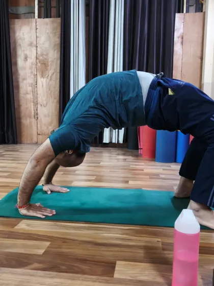 A practitioner holds a deep Wheel Pose, showcasing excellent spinal flexibility and shoulder opening. Regular practice of backbends can help counteract the effects of sitting for long hours.