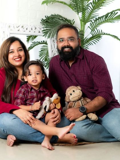 A cozy and casual family portrait. This photo captures the relaxed and happy bond between these parents and their little boy.