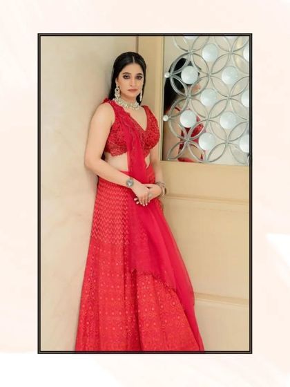 Our client looks beautiful in this red chikankari lehenga, a perfect choice for a wedding guest.