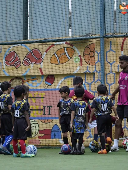 A coach gathers the youngest group of players to explain the next drill, ensuring they understand the instructions.