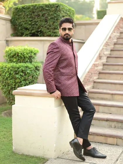 The same client, posing on a staircase in his maroon Jodhpuri. The classic cut and rich color make it a versatile and stylish piece.