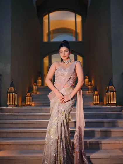 A full-length shot of the "Almora" look on a grand staircase. The styling is dramatic and designed to make a statement.