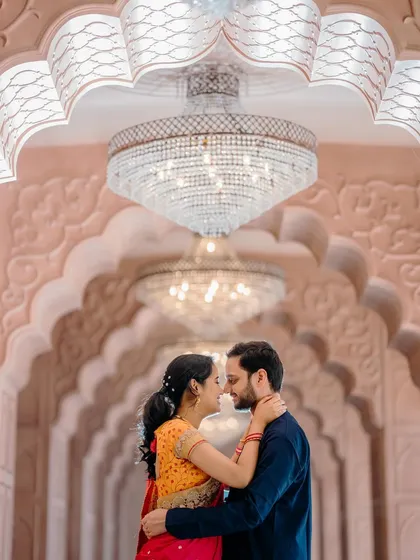 A grand and architectural pre-wedding portrait. The repeating arches and magnificent chandelier create a stunning, regal backdrop for Sayali and Siddhesh's romantic photo.