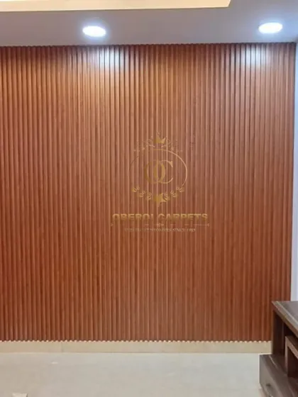 A close-up view of a full wall installation featuring our rich, brown wood-tone fluted panels. The consistent vertical lines create a sense of height and elegance in the room.