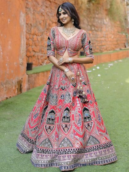 A full-length view of our red lehenga with distinctive black and silver embroidery. The A-line skirt and matching jacket-style blouse create a flattering and modern silhouette.