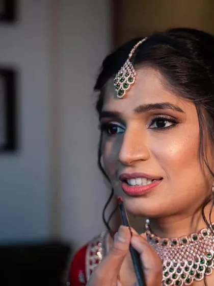 A behind-the-scenes shot of me applying a bold red lip for the Sangeet. This final touch adds a pop of color and completes the glamorous evening look.
