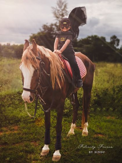 Not all heroes wear capes, but this one does! A four-year-old Batman enjoying a ride on his trusty steed.