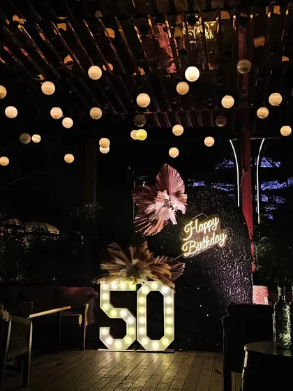 Another angle of the 50th birthday decor, highlighting the 'Happy Birthday' neon sign against the dark sequin backdrop. The contrast makes the sign pop beautifully.