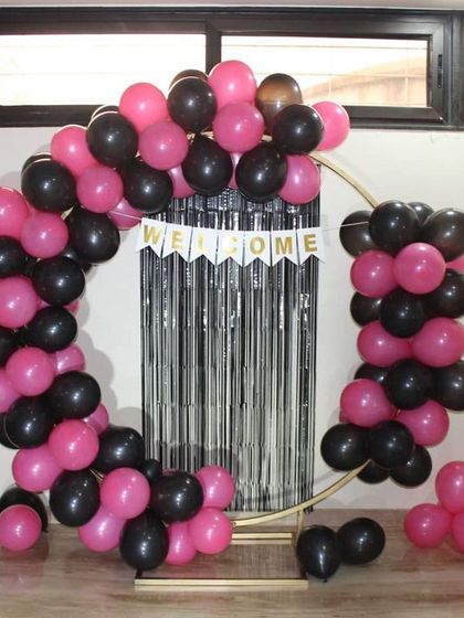 Another look at the circular welcome home arch. The pink and black balloons are arranged to create a dynamic, asymmetrical design that is both modern and celebratory.