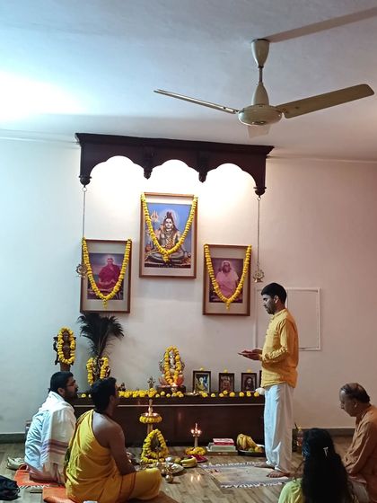 A puja being performed in front of the portraits of our Gurus on Swami Vishnudevananda's mahasamadhi day, a day of remembrance.