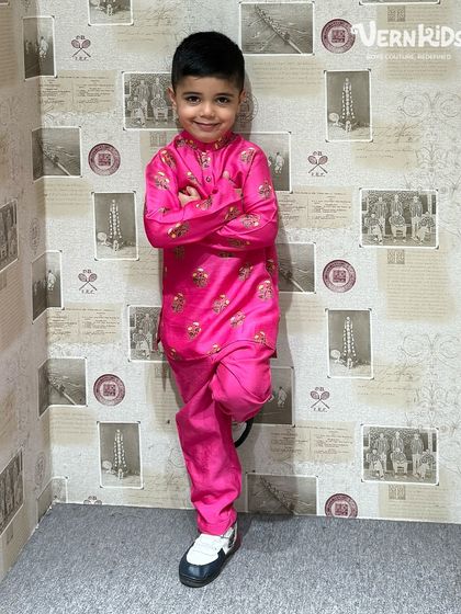 A full-length view of our client in a bright pink printed kurta set, showing off his confident pose and the comfortable fit of the outfit.