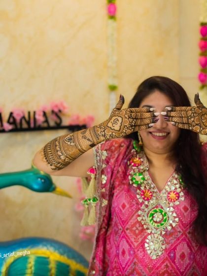 A fun and happy shot of a bride-to-be, her hands covered in beautiful henna. These are the moments that make the mehendi ceremony so special.