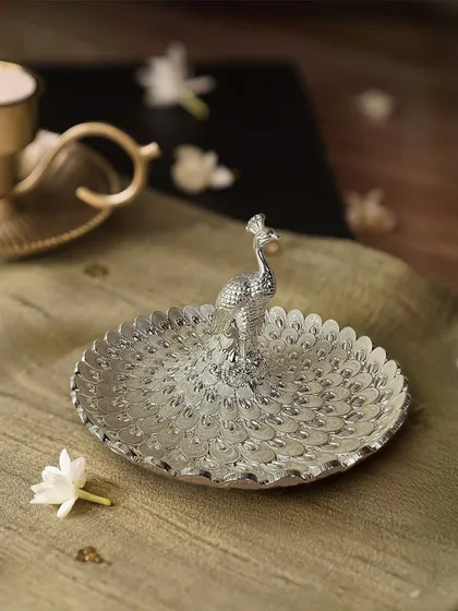 A simple yet elegant statement piece. This silver-plated peacock tray is perfect for serving small appetizers, holding trinkets, or simply adding a touch of metallic shine to your coffee table.
