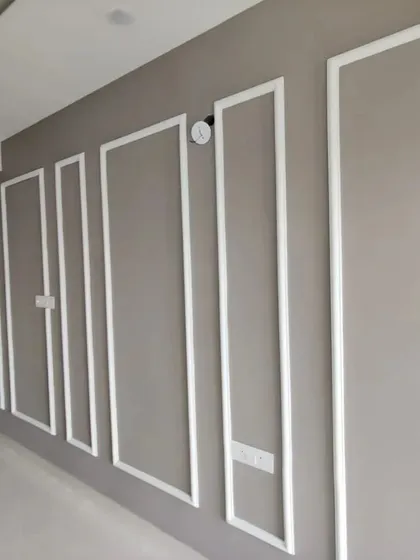 Elegant wall moulding in a contrasting white adds architectural detail and a classic, sophisticated feel to this neutral-toned hallway.