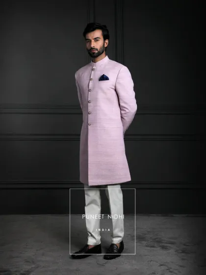 A simple yet elegant lavender Achkan in rich silk, styled with a sleek straight fit and mandarin collar. This piece blends quiet grandeur with refined craftsmanship.