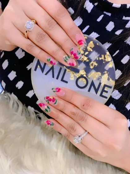 Floral nail art is one of our specialties. Here, we've hand-painted delicate pink and red flowers over a soft, translucent base on elegant almond-shaped nails. This design is timeless, feminine, and showcases the detailed brushwork our artists are known for.