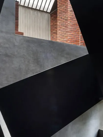 An abstract, geometric composition of the staircase at the Brick House, highlighting the interplay of form and material.