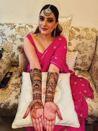 A beautifully dressed bride showcasing her full-arm mehandi, ready for her wedding festivities.