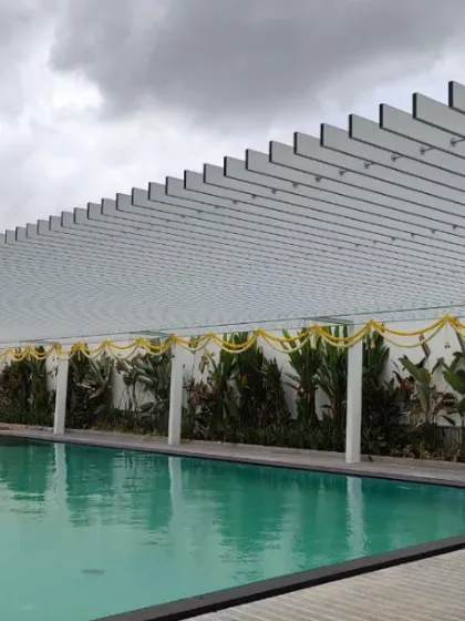 Shaded sophistication meets poolside perfection. This sleek white pergola provides a structured yet open-air covering for a tranquil swimming pool area.