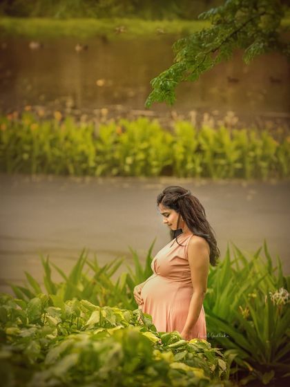 A quiet, contemplative moment by the water. This portrait captures the mother-to-be looking down at her bump, surrounded by the calm and tranquility of nature.