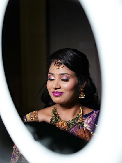 A creative shot using a ring light to frame Aarthi's face, showcasing her beautiful reception makeup.