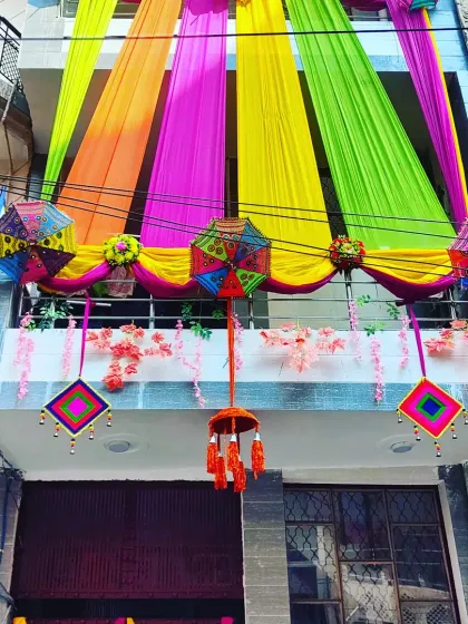 A colourful balcony decoration with hanging tassels and umbrellas, adding a festive touch to the upper level of the home.