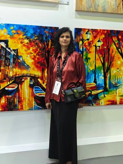 Artist Ria Aboobakar with her vibrant impressionist cityscapes at World Art Dubai. We proudly showcase the diverse talent within our artist community on the global stage.