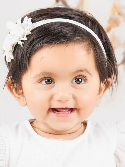 A sweet and simple close-up portrait of a smiling baby girl. Her happiness shines through.