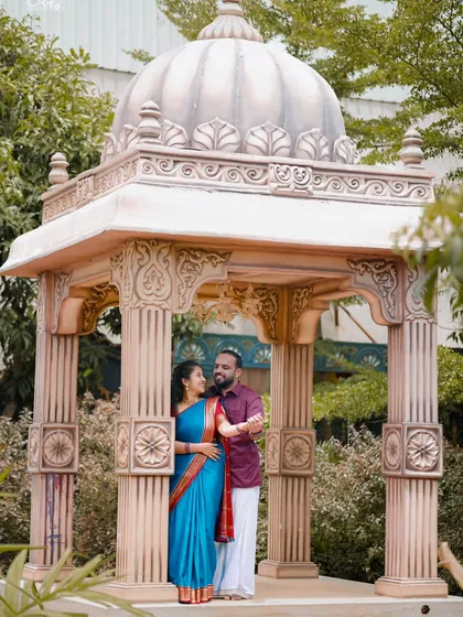 This couple looks regal in their traditional outfits, posing inside a beautifully detailed gazebo. We ensure every element, from costume to location, is perfect.