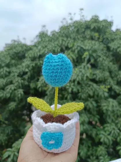 A cute potted blue tulip with a flower detail stitched onto the pot.