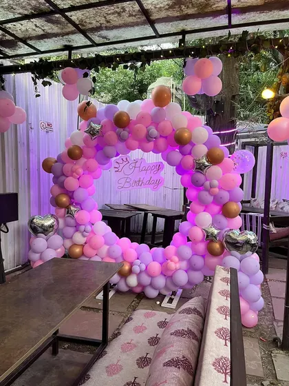Another angle of the outdoor birthday setup, showing the full balloon ring.