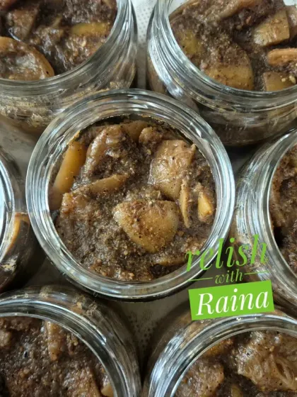 A closer look at the texture of the black lemon pickle. The lemon pieces are coated in a thick, dark masala. It's a sour and medium-spicy pickle that is a traditional Rajasthani delicacy.