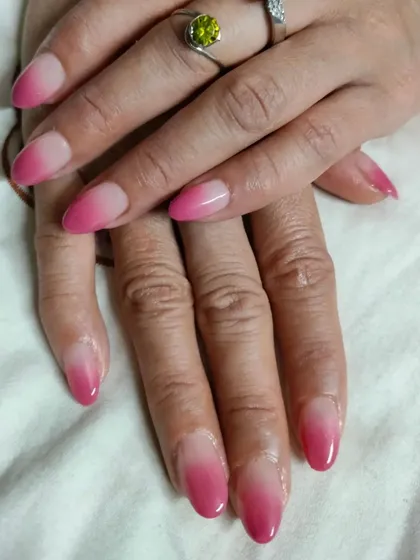 A classic pink ombre on almond-shaped nails, blending from a natural base to a rich, deep pink.