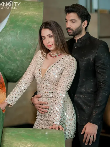 A high-fashion, editorial-style portrait of Malvika and Pranav. The pose is confident and chic, highlighting their star quality while keeping the connection between them as the central focus.
