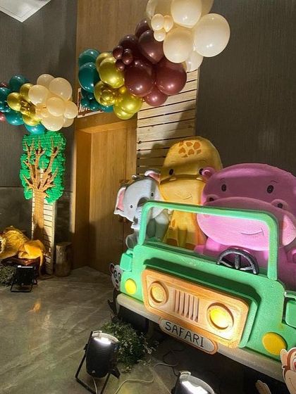 A fun photo opportunity with a safari jeep prop filled with friendly animal characters, perfect for a kid's birthday party.
