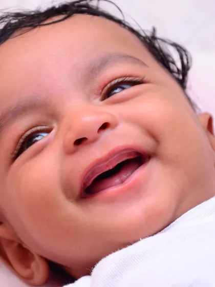 A joyful close-up capturing a baby's genuine, heartwarming smile. We focus on creating a relaxed atmosphere to capture these fleeting, precious expressions during our baby photoshoots.