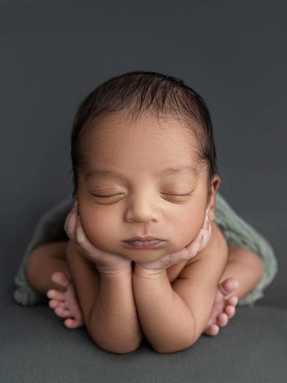 A perfectly symmetrical 'chin on hands' pose. I am trained to achieve this advanced pose safely, always prioritizing your baby's comfort.