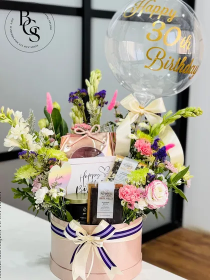 Celebrating a 30th birthday calls for something truly special. This stunning hatbox arrangement combines a lush bouquet of fresh flowers with curated gifts and a personalized "Happy 30th Birthday" balloon, creating a spectacular and joyful surprise that is available for delivery in Mumbai.