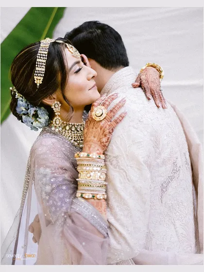 A heartfelt embrace between the bride and groom. Her eyes are closed in blissful contentment, a serene moment of love and connection.