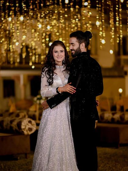 A classic couple portrait from an engagement night at Amar Mahal, Orchha. The backdrop of hanging lights creates a magical and festive atmosphere for the celebration.
