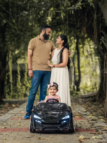 We love taking our sessions outdoors into Delhi's parks, where natural light and beautiful scenery create a relaxed atmosphere. This family portrait showcases a playful moment, with our miniature toy car adding a touch of fun for the little one.