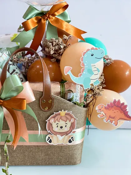 The combination of rustic jute, soft ribbons, and playful dinosaur and lion cutouts gives this hamper a unique and charming feel.