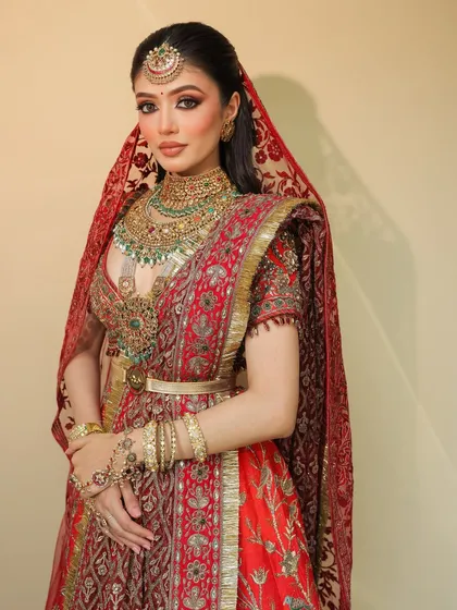 A full-length view of this royal bridal look. The makeup was designed to be timeless, balancing the grandeur of the red JJ Valaya outfit and the intricate Shrihari Diagems jewelry.