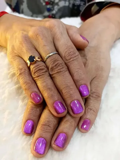 This look showcases the magical effect of cateye gel polish. I applied this shimmering purple cateye polish over natural nails for a client's special event. The magnetic polish creates a deep, shifting line of light that is truly captivating.
