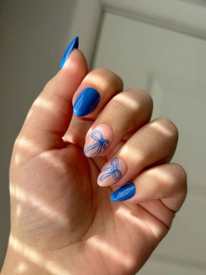 Nail inspiration for a blue coquette set with delicate, hand-drawn bows.