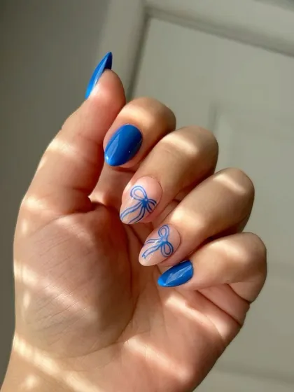 Nail inspiration for a blue coquette set with delicate, hand-drawn bows.